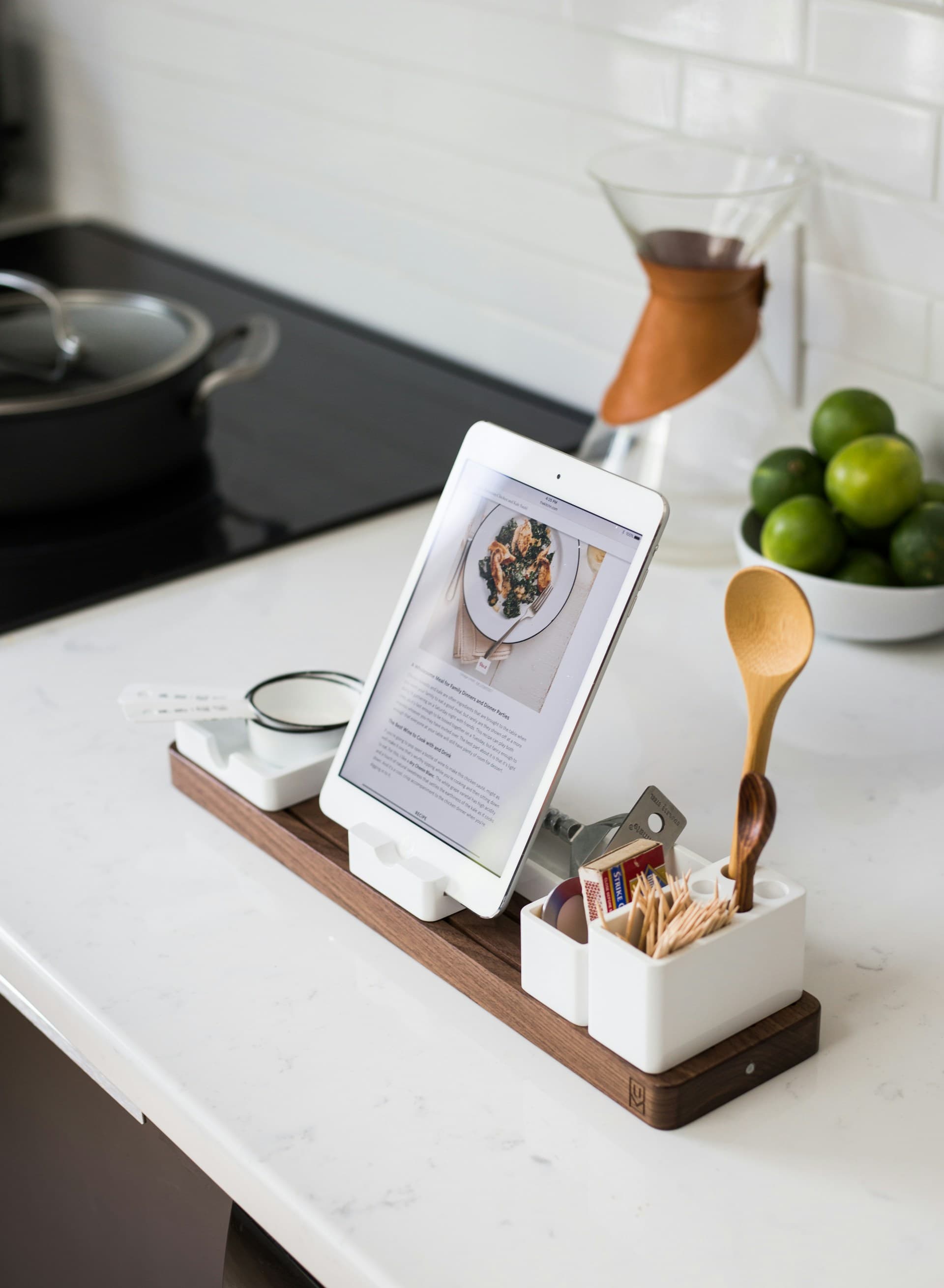 Tablet displaying a recipe beside kitchen utensils and ingredients on a counter
